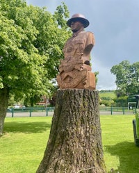 a statue of a soldier on top of a tree stump