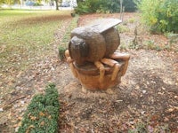 a sculpture of a bee sitting on a stump