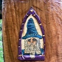 a statue of a wizard on a tree stump