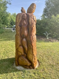 a wooden sculpture in a grassy area