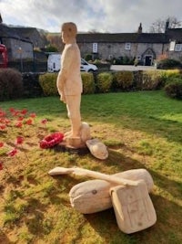 a wooden statue of a soldier in a field