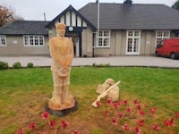 a wooden statue of a soldier in front of a building