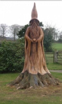 a statue of a gnome on a tree stump