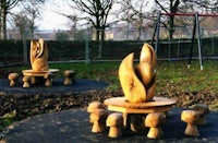 a wooden sculpture of a flower in a park