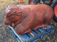 a large statue of a cow sitting on a pallet