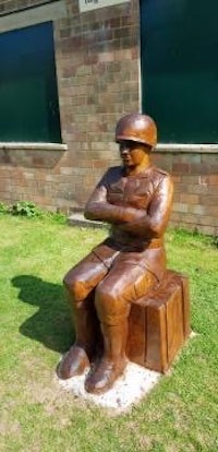 a statue of a soldier sitting on a bench
