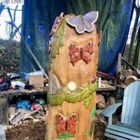 a wooden tree stump with butterflies on it