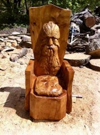 a wooden throne with a bearded man sitting on it