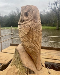 a wood carving of an owl on top of a tree stump