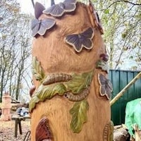 a carved tree stump with butterflies on it