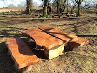 a picnic table and benches in a wooded area