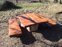 a wooden picnic table in a wooded area