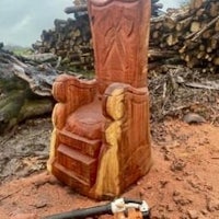 a wooden throne sitting on a pile of logs