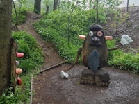 a statue of a gnome in the woods