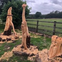 a group of tree stump carvings in a field