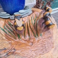 a wooden sculpture of bees on a tree stump