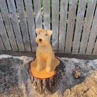 a wooden dog sitting on top of a tree stump