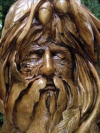 a wooden sculpture of a man with a beard and long hair