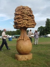 a large sculpture of a tree on a grassy field