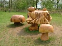 a wooden sculpture of a mushroom in a park