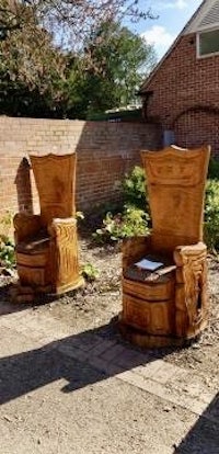 a group of wooden chairs in front of a house