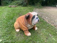 a statue of a bulldog sitting on the grass