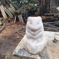 a wooden sculpture of a hamster sitting on a stump