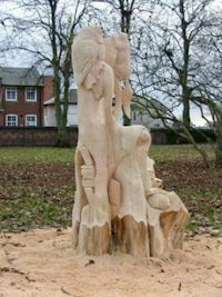 a tree stump with a carving of a woman and a child