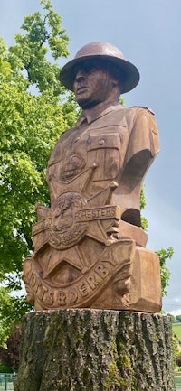 a statue of a soldier with a hat on top of a tree