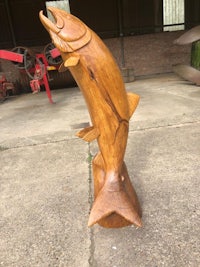 a wooden sculpture of a fish in a barn