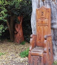 a wooden throne next to a tree