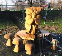 a wooden sculpture of a tree in a park