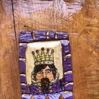 a wooden plaque with a picture of a king on it