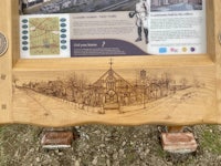 a wooden sign with a drawing of a building on it