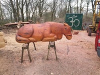 a wooden sculpture of a horse in the woods