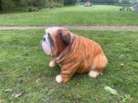 a statue of a bulldog sitting on the grass