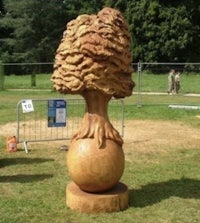 a sculpture of a tree on a grassy field