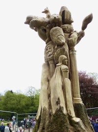 a tree with carvings on it in a park