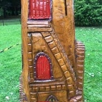 a wooden statue of a castle with a red door