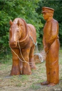 a wooden statue of a man and a horse