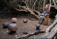 a group of wooden sculptures in a wooded area