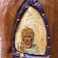 a piece of wood with a painting of a girl in a dress