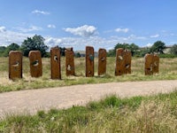 a group of wooden sculptures in a grassy field