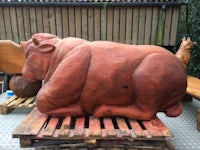 a large wooden sculpture of a rhino on a pallet