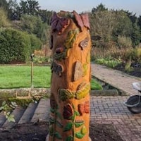 a wooden tree stump in a garden