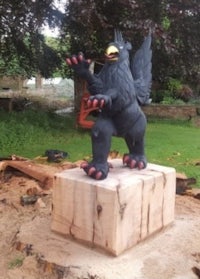 a statue of a black bird on top of a block of wood