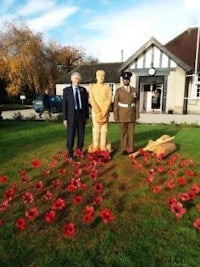 two men standing next to a statue of a soldier