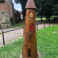 a wooden statue of a castle in a park