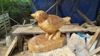 a wood carving of a bird on top of a piece of wood