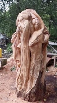 a sculpture made from a tree in a wooded area